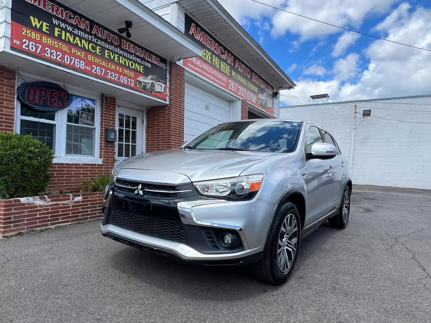 2018 Mitsubishi Outlander Sport in a scenic outdoor setting, highlighting its sleek design, bold grille, and compact SUV styling.