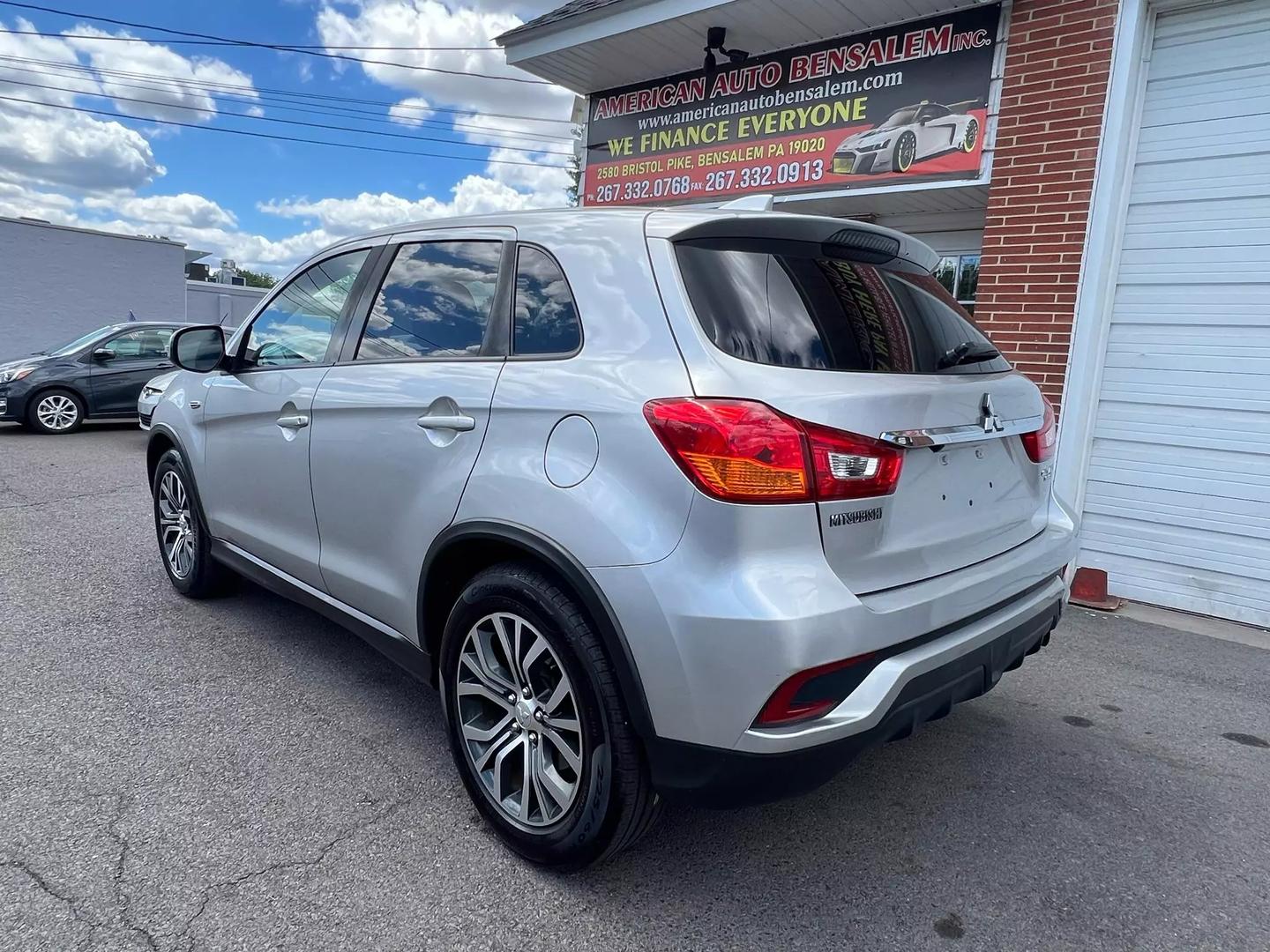 2018 Mitsubishi Outlander Sport in a scenic outdoor setting, highlighting its sleek design, bold grille, and compact SUV styling.