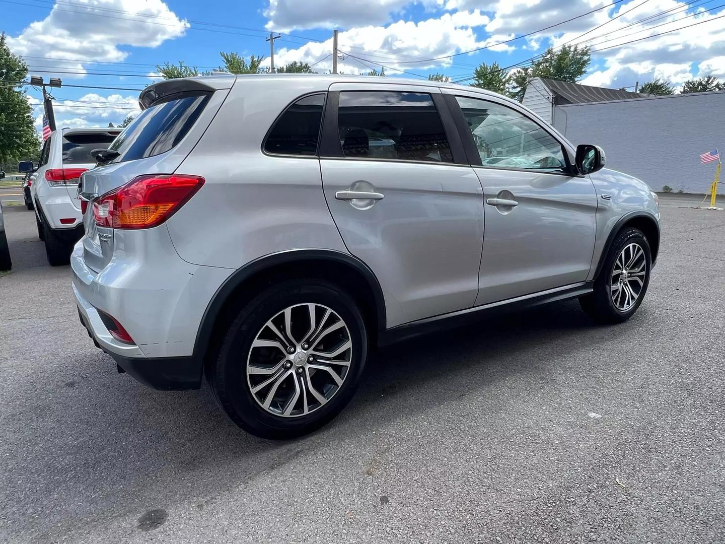 2018 Mitsubishi Outlander Sport in a scenic outdoor setting, highlighting its sleek design, bold grille, and compact SUV styling.