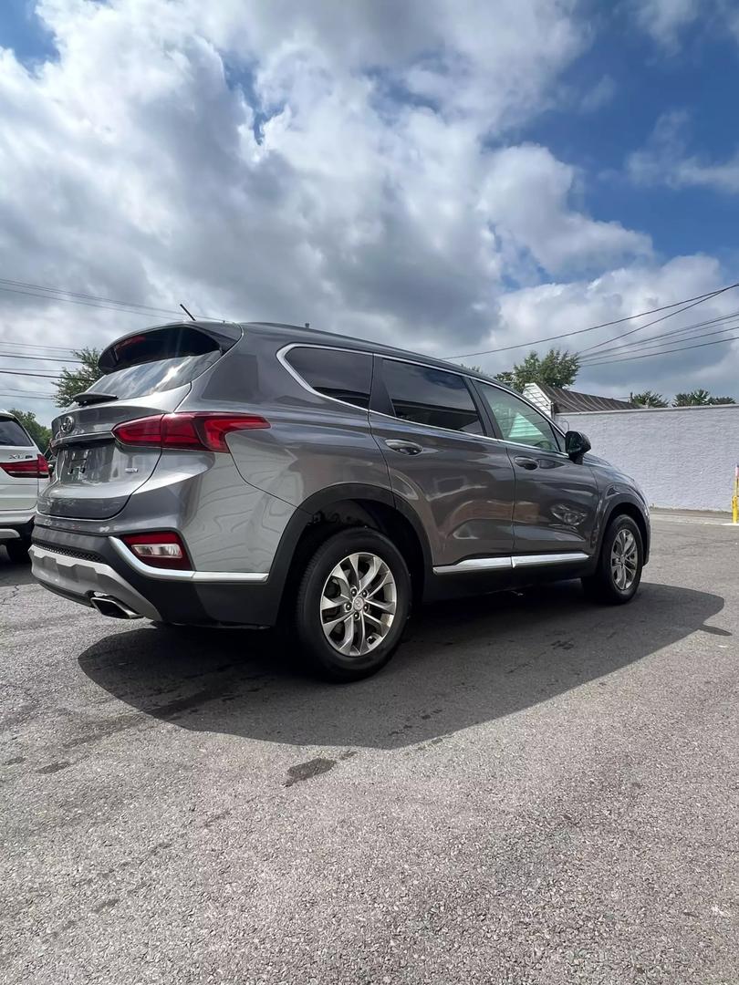 2019 Hyundai Santa Fe SUV in grey, showcasing spacious 5-seat interior, modern design, and advanced safety features, ideal for comfortable family travel and road trips.