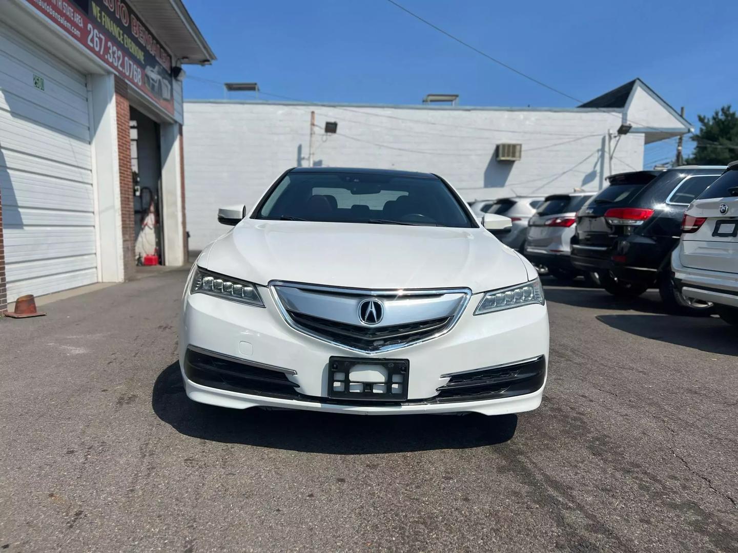 A sleek 2015 Acura TLX parked on a scenic road, showcasing its modern design, elegant lines, and stylish exterior in natural light.