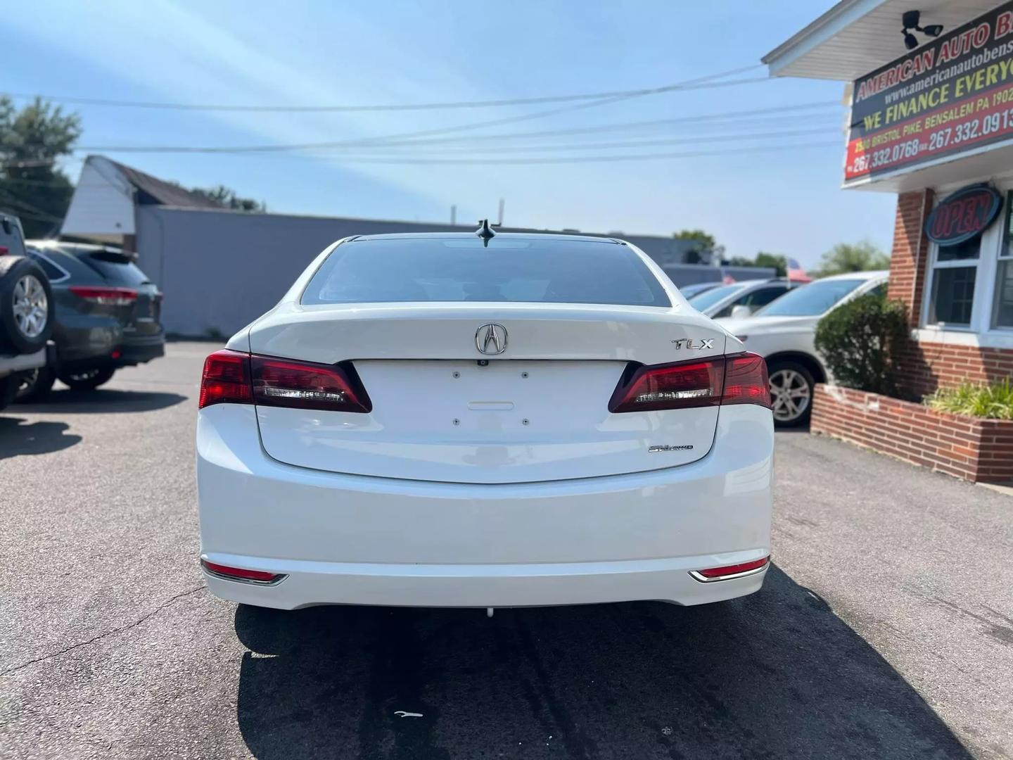 A sleek 2015 Acura TLX parked on a scenic road, showcasing its modern design, elegant lines, and stylish exterior in natural light.