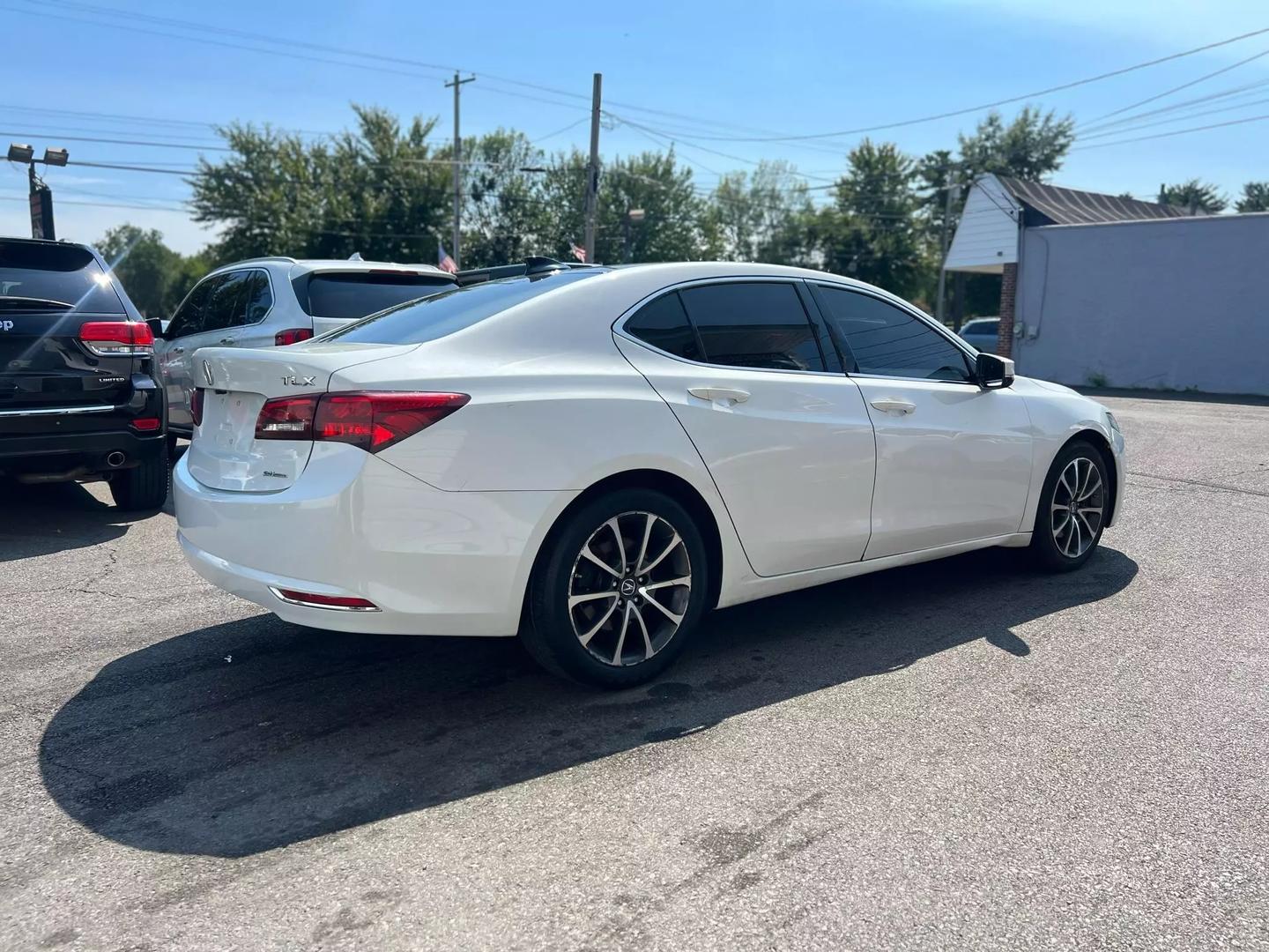 A sleek 2015 Acura TLX parked on a scenic road, showcasing its modern design, elegant lines, and stylish exterior in natural light.