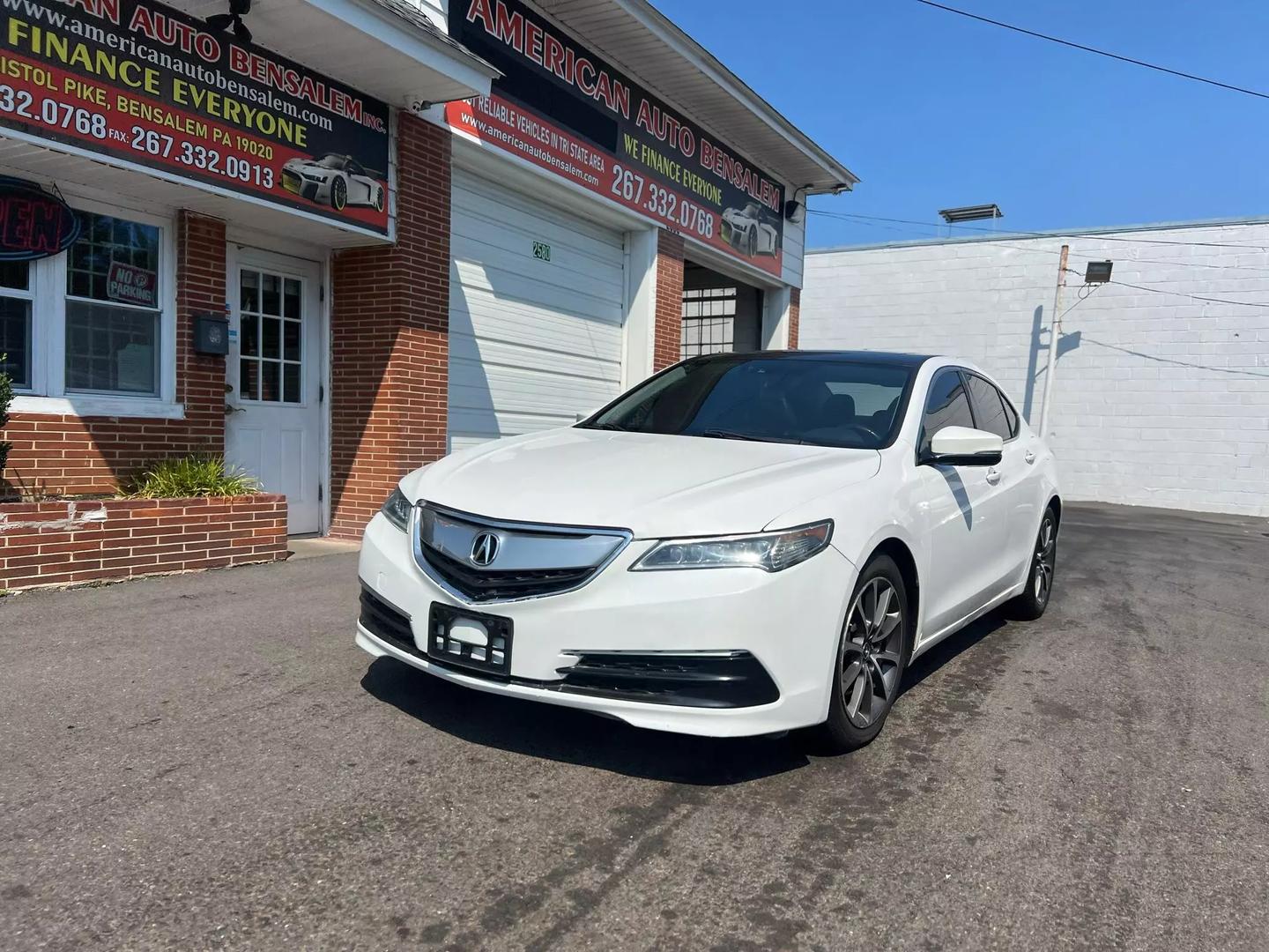 A sleek 2015 Acura TLX parked on a scenic road, showcasing its modern design, elegant lines, and stylish exterior in natural light.