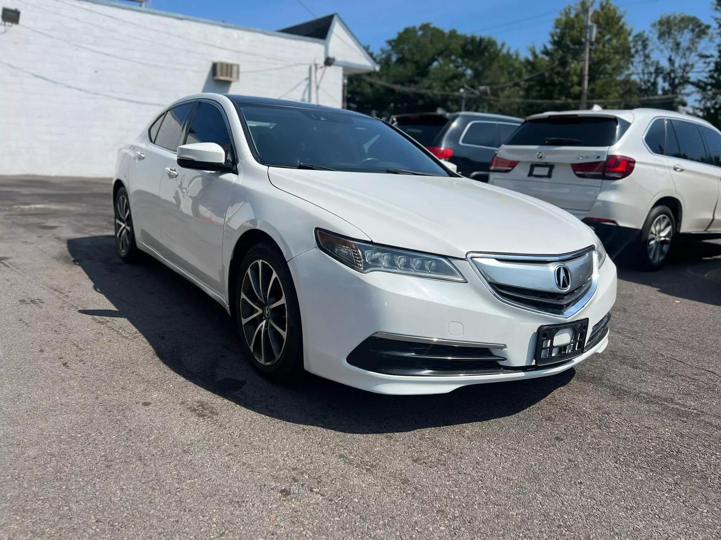 A sleek 2015 Acura TLX parked on a scenic road, showcasing its modern design, elegant lines, and stylish exterior in natural light.