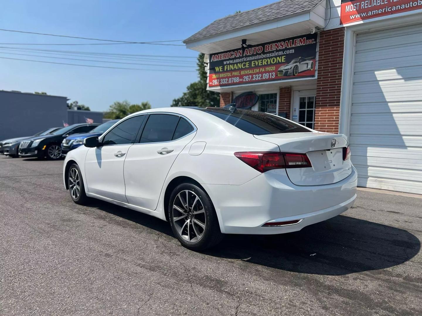 A sleek 2015 Acura TLX parked on a scenic road, showcasing its modern design, elegant lines, and stylish exterior in natural light.