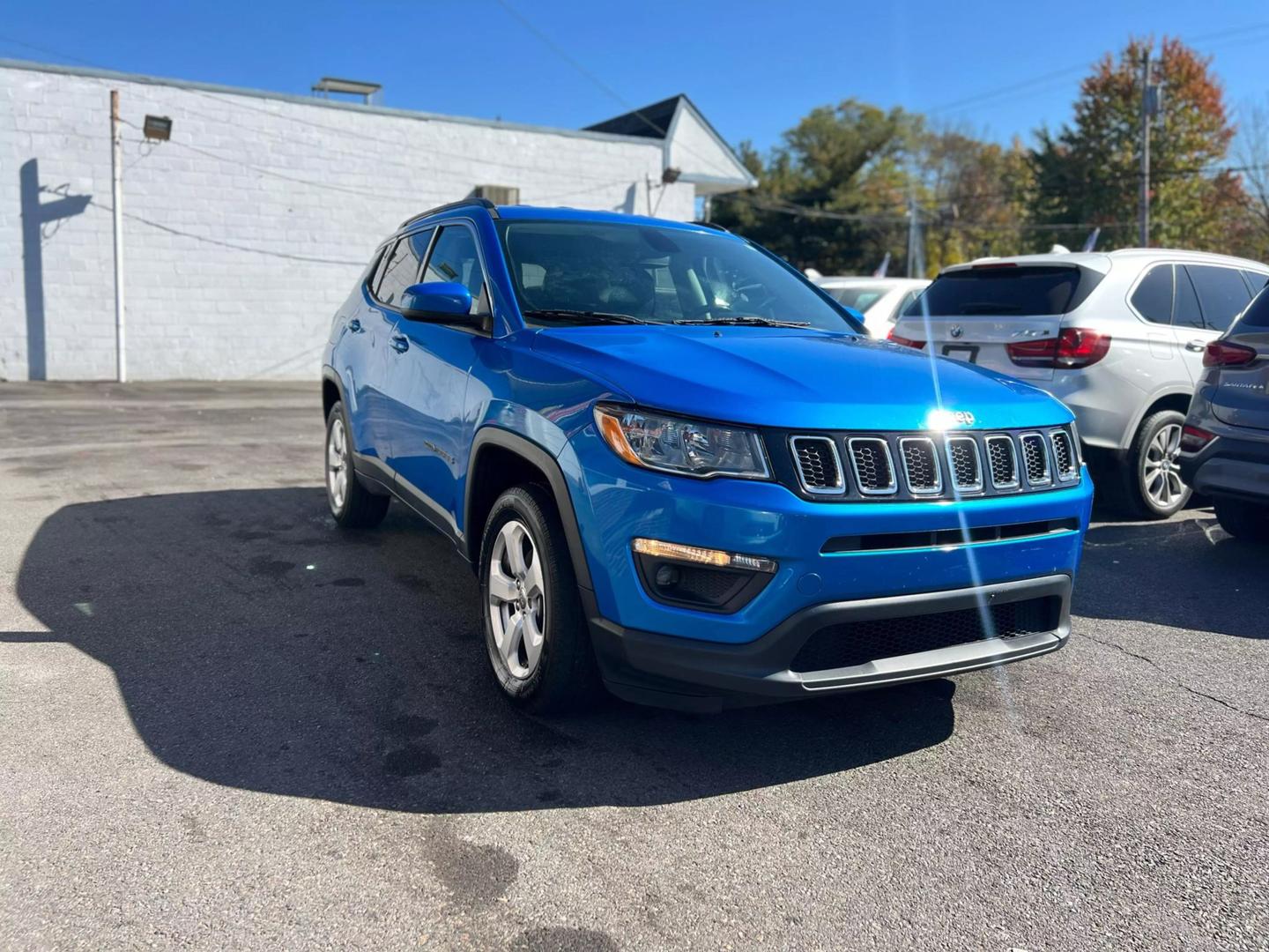 Front view of a 2020 Jeep Compass parked outdoors, showcasing its bold design and rugged build.