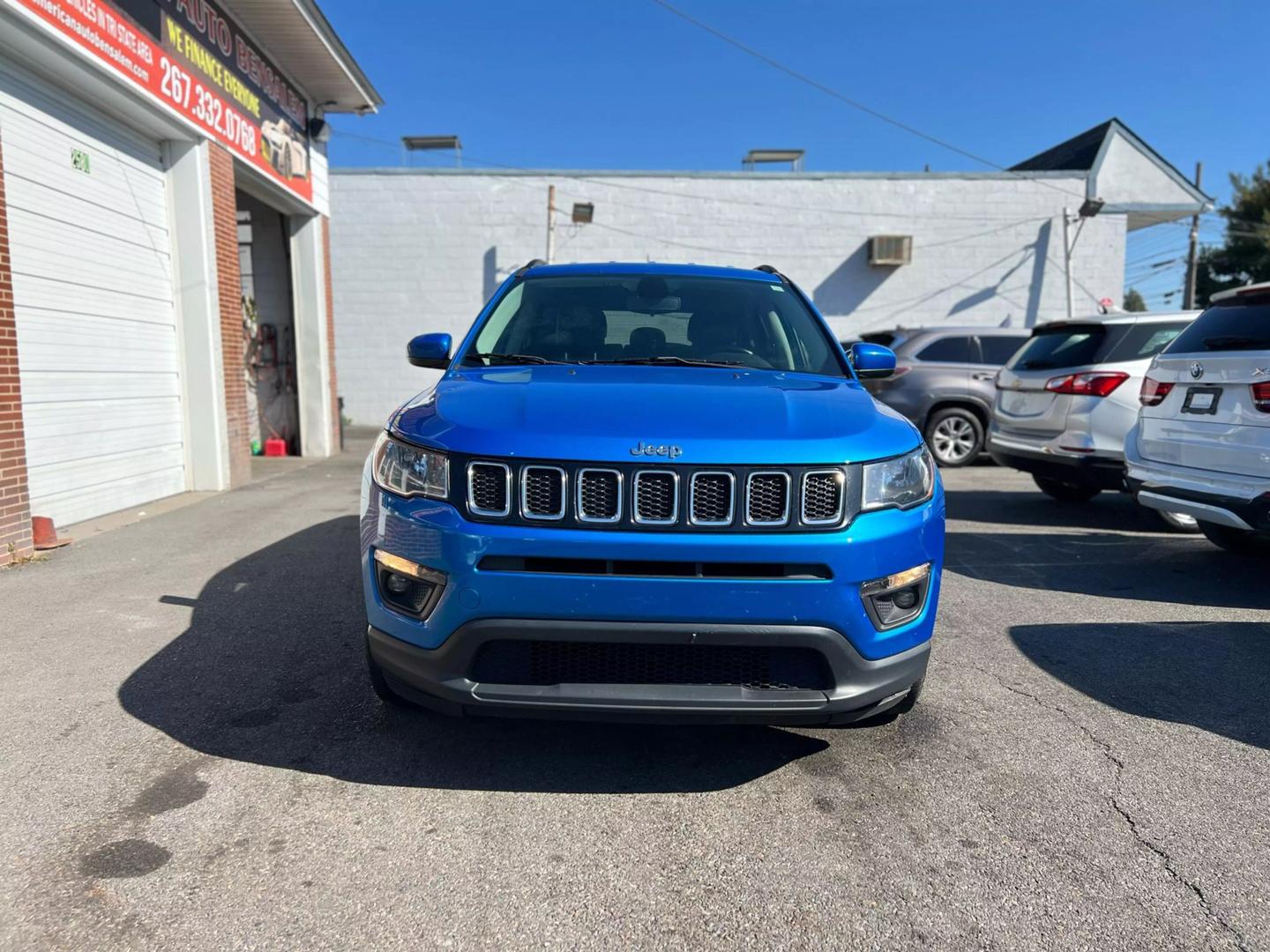 Front view of a 2020 Jeep Compass parked outdoors, showcasing its bold design and rugged build.